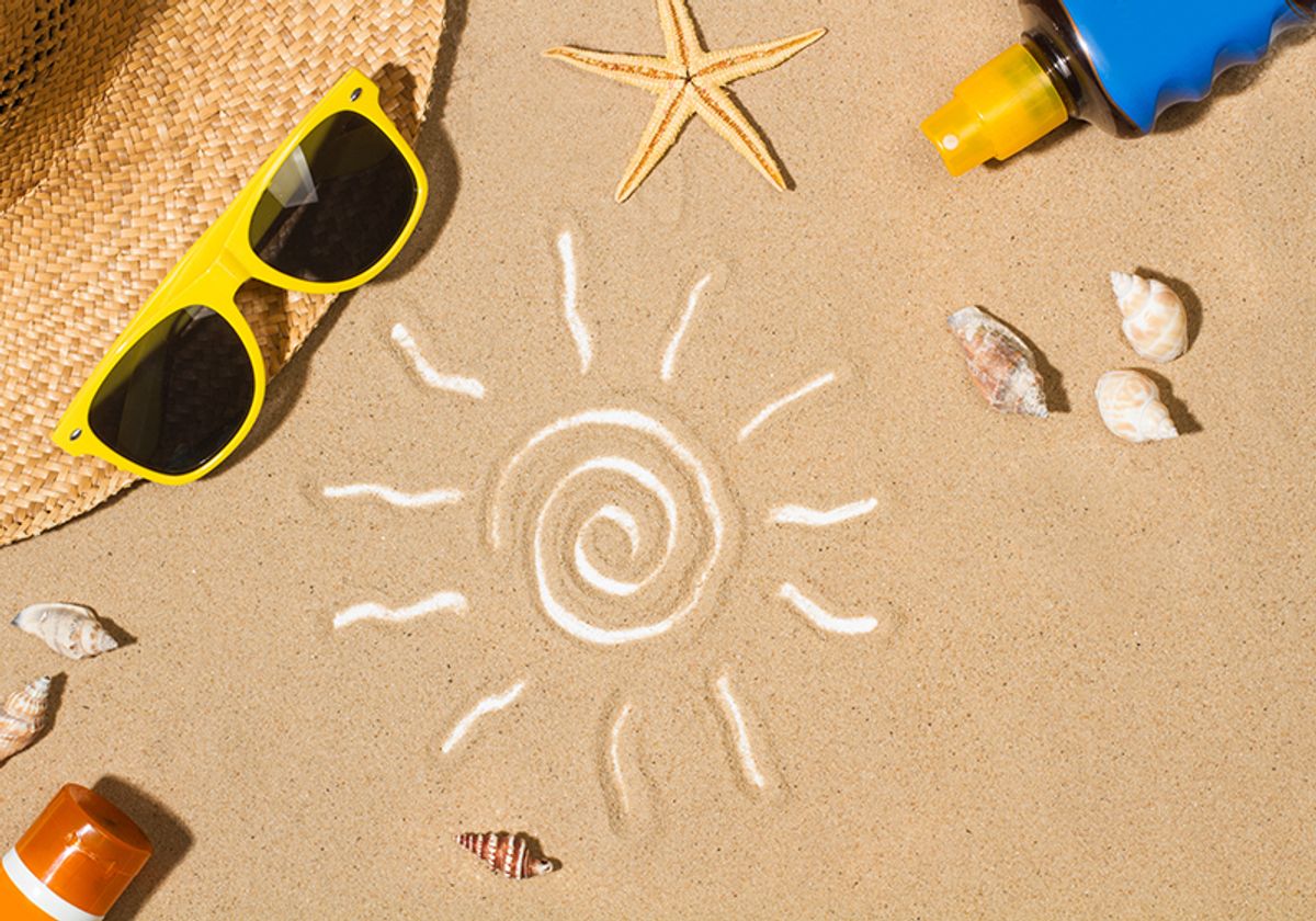 A drawing of the sun on the sand, surrounded by items that people use to protect themselves from UV damage, including sunscreen, a hat, and sunglasses.