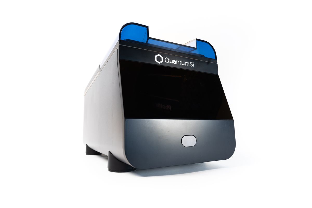 A photo of the PlatinumTM Next-Generation Protein Sequencer, a small roughly cube-shaped blue-black-silver instrument.