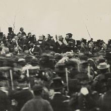 In one of the only known photos of Abraham Lincoln taken on the day of the Gettysburg Address, Lincoln can be seen seated, hatless, just below and to the right of the flag. Lincoln began developing symptoms of smallpox on the train home to Washington, DC.