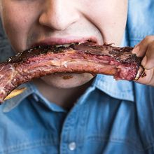 man having grilled beef ribs